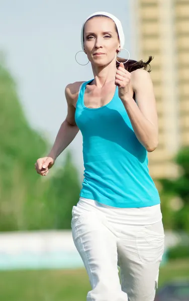 Красива жінка біжить в зеленому парку — стокове фото