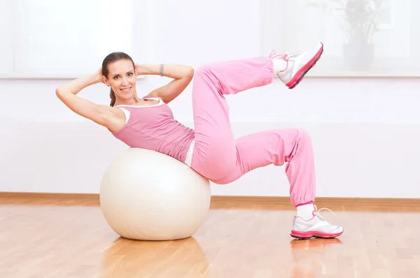 Mulher fazendo exercício de alongamento na bola — Fotografia de Stock