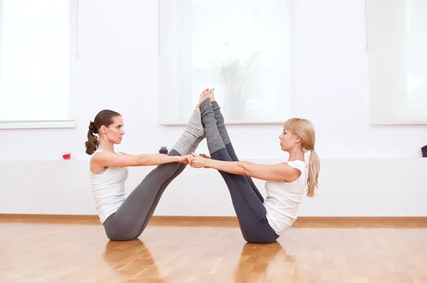 Mujeres haciendo ejercicio de yoga en el gimnasio — Foto de Stock