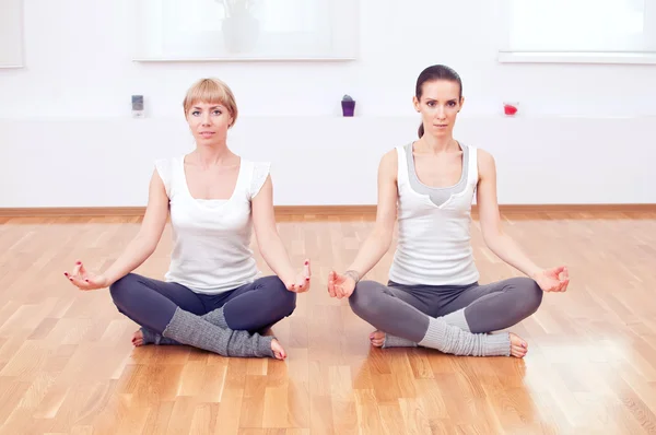 Mujeres haciendo ejercicio de yoga en el gimnasio — Foto de Stock