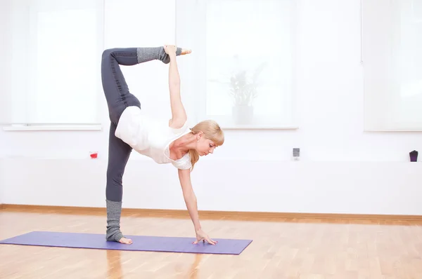 Vrouw doen stretching oefening van de yoga op sport sportschool — Stockfoto