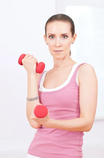 Donna che fa esercizio manubri in palestra sportiva — Foto Stock