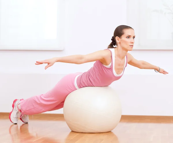 Mulher fazendo exercício de alongamento na bola — Fotografia de Stock