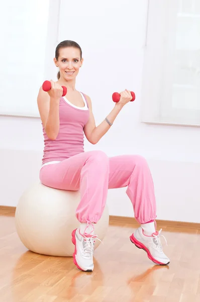 Woman doing dumbbell exercise at sport gym — Stock Photo, Image