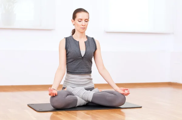 Vrouw doen stretching oefening van de yoga op sport sportschool — Stockfoto