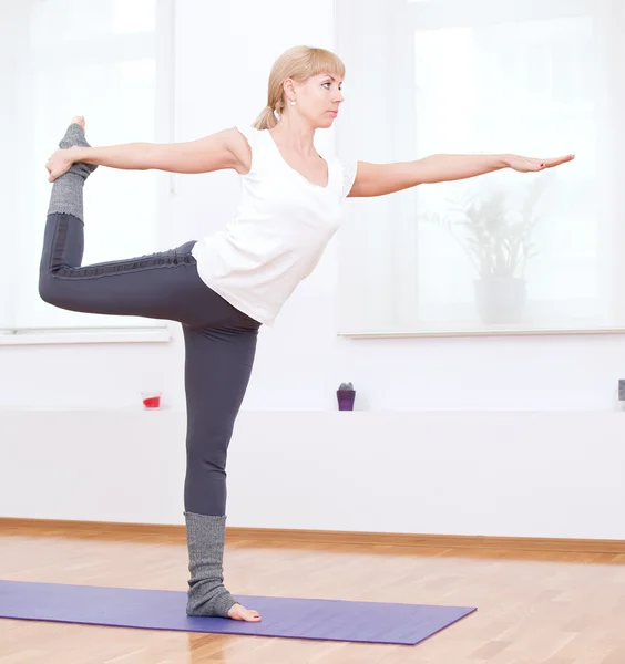 Vrouw doen stretching oefening van de yoga op sport sportschool — Stockfoto