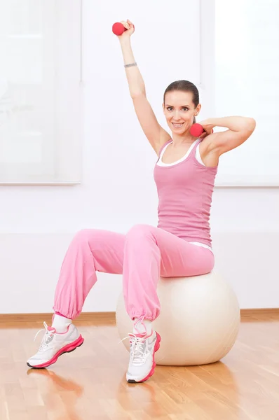 Woman doing dumbbell exercise at sport gym — Stock Photo, Image