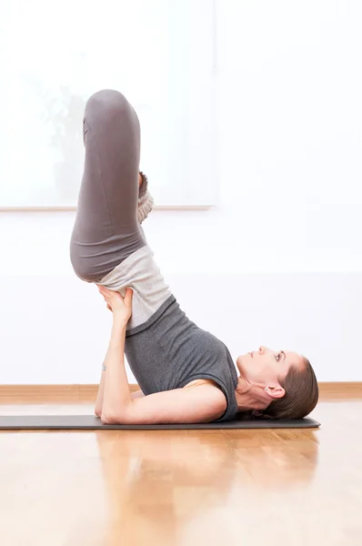 Woman doing stretching yoga exercise at sport gym — Stock Photo, Image