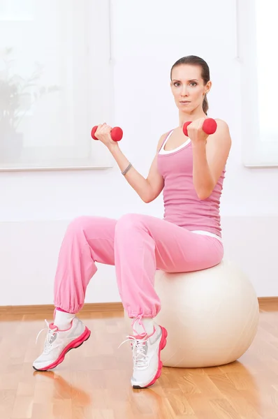 Mujer haciendo ejercicio de mancuerna en gimnasio deportivo — Foto de Stock