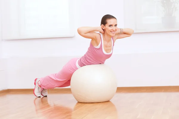 Woman doing stretching exercise on ball — Stockfoto