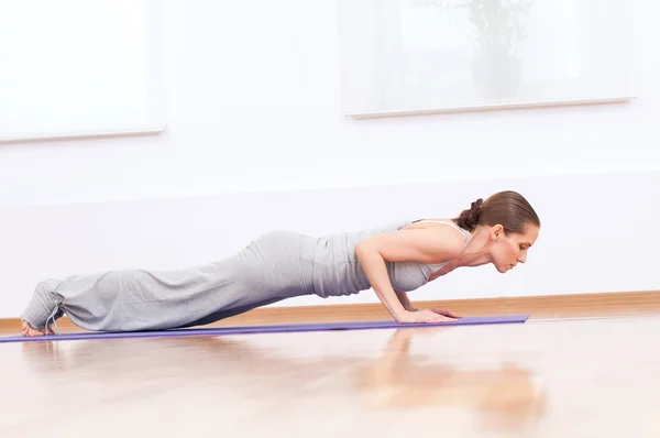 Женщина делает упражнения йоги на растяжку в спортзале — стоковое фото
