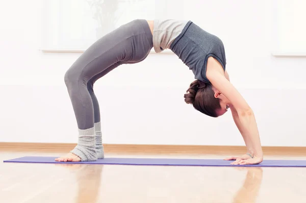 Vrouw doen stretching oefening van de yoga op sport sportschool — Stockfoto