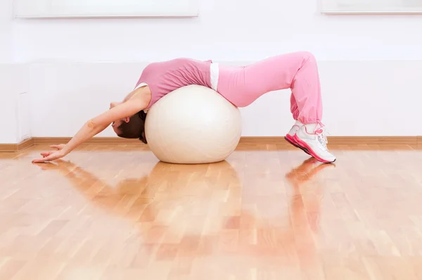 Woman doing stretching exercise on ball — Stockfoto