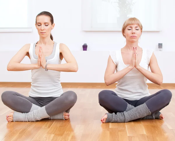 Mujeres haciendo ejercicio de yoga en el gimnasio — Foto de Stock