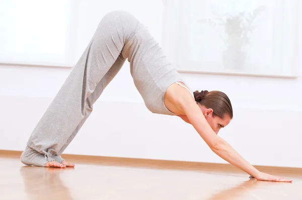 Женщина делает упражнения йоги на растяжку в спортзале — стоковое фото