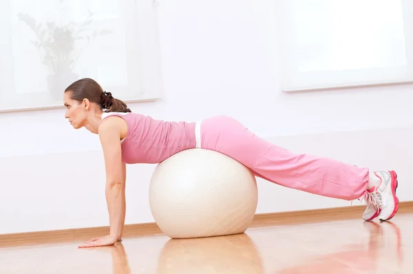 Woman doing stretching exercise on ball — Stok fotoğraf