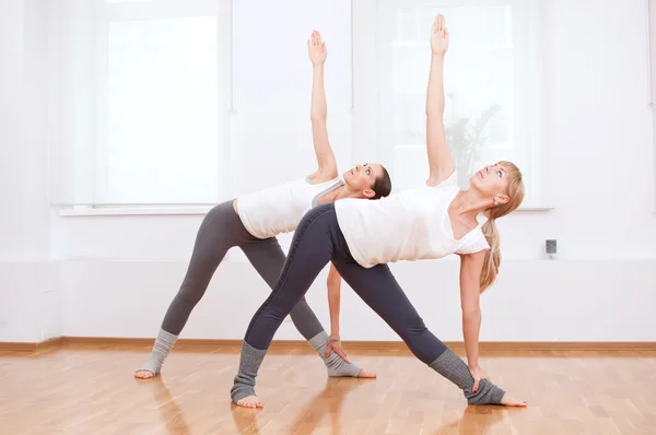 Mujeres haciendo ejercicio de yoga en el gimnasio — Foto de Stock