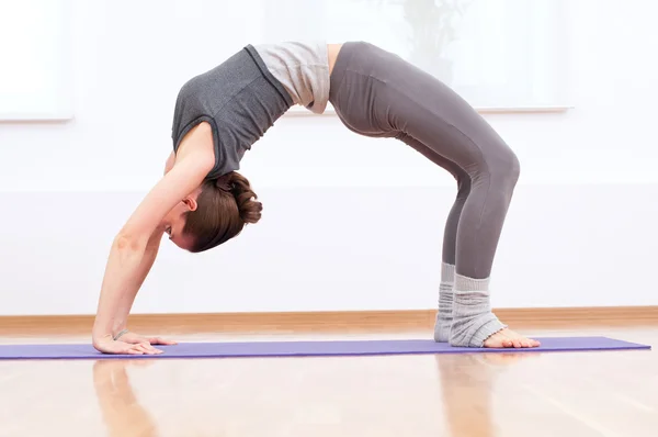 女人在体育健身房锻炼伸展瑜伽 — 图库照片