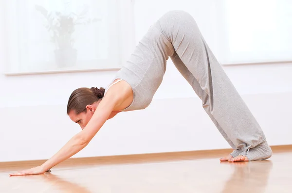 Mujer haciendo ejercicio de yoga estiramiento en gimnasio deportivo — Foto de Stock