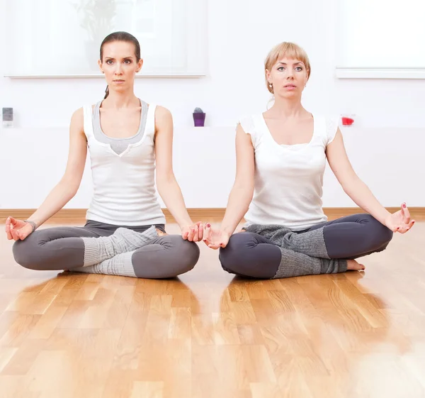 Mujeres haciendo ejercicio de yoga en el gimnasio —  Fotos de Stock