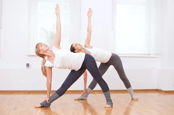 Mujeres haciendo ejercicio de yoga en el gimnasio — Foto de Stock