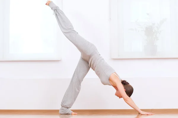Kvinnan gör stretching yoga övning på sport gym — Stockfoto