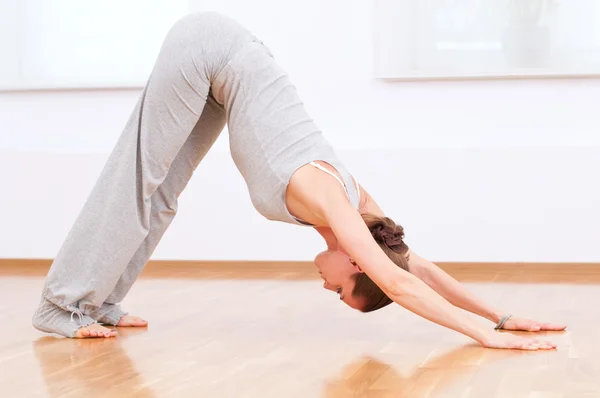 Mujer haciendo ejercicio de yoga estiramiento en gimnasio deportivo —  Fotos de Stock