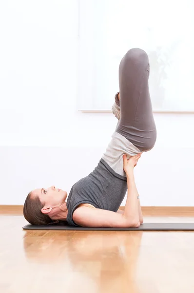 Vrouw doen stretching oefening van de yoga op sport sportschool — Stockfoto