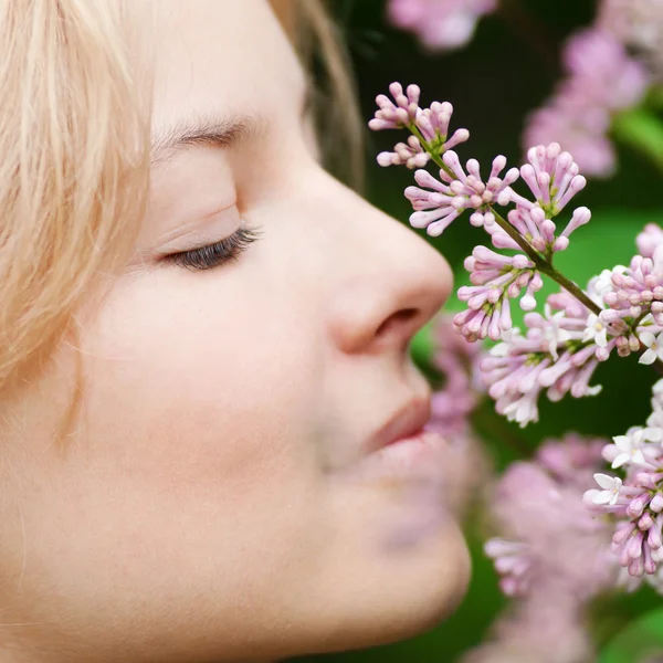 Woman with lilac flower on face Stock Photo