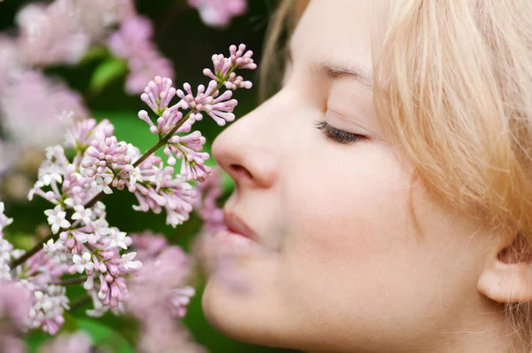 Woman with lilac flower on face Royalty Free Stock Images