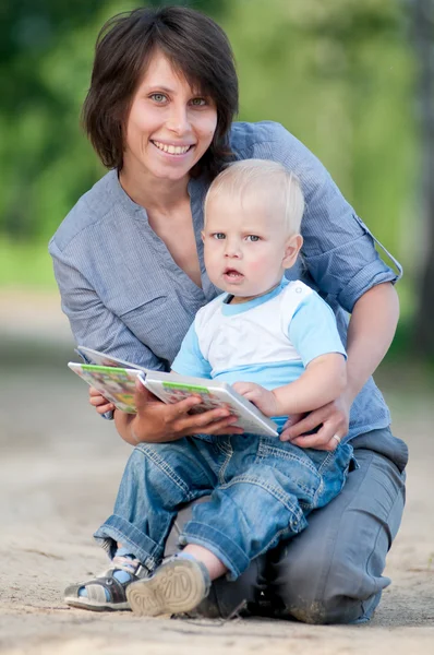 Mamma med son läser en bok — Stockfoto