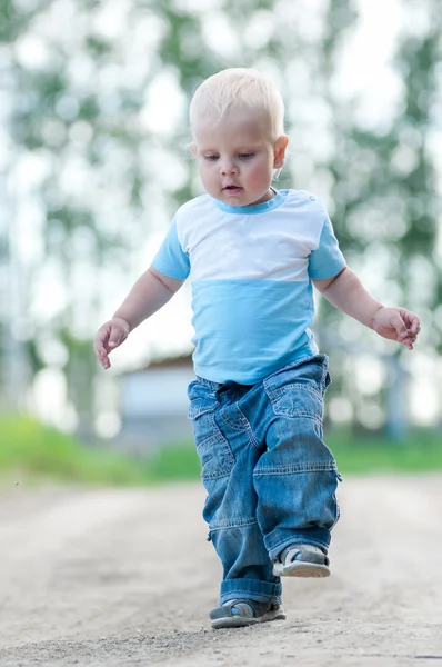 Счастливый маленький мальчик в зеленом парке — стоковое фото