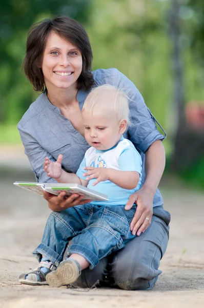 Mamma med son läser en bok — Stockfoto