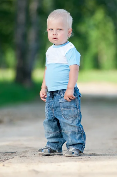 Счастливый маленький мальчик в зеленом парке — стоковое фото