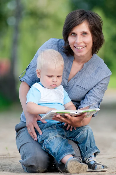 Mamma med son läser en bok — Stockfoto