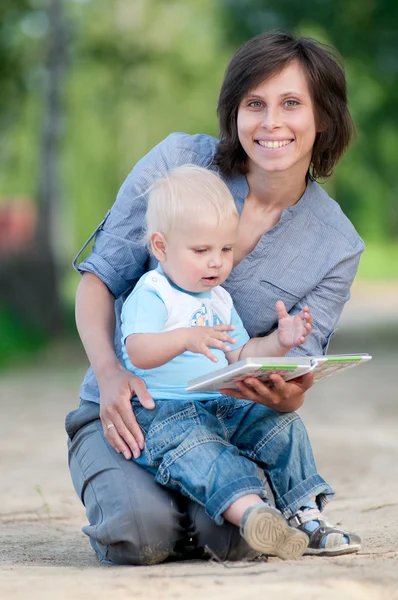 Mamma med son läser en bok — Stockfoto