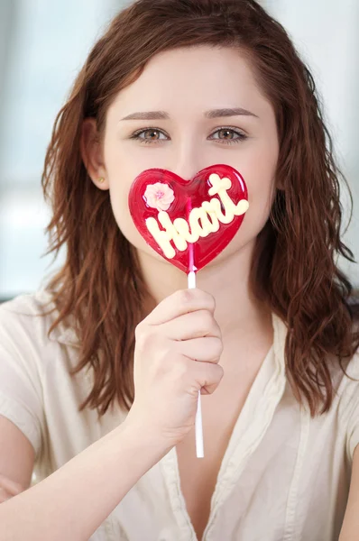 Pretty woman with candy heart — Stock Photo, Image