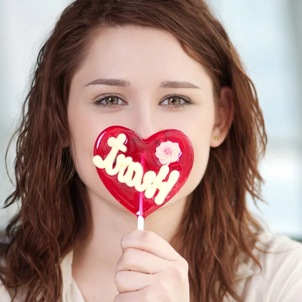 Pretty woman with candy heart — Stock Photo, Image