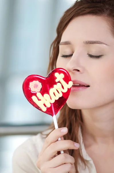 Pretty woman with candy heart — Stock Photo, Image