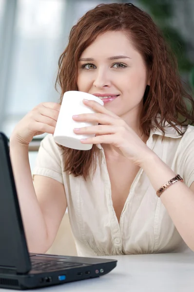 Donna d'affari con un computer portatile e tazza — Foto Stock