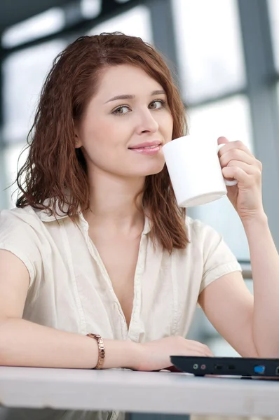 ノート パソコンとマグカップを持つ女性実業家 — ストック写真