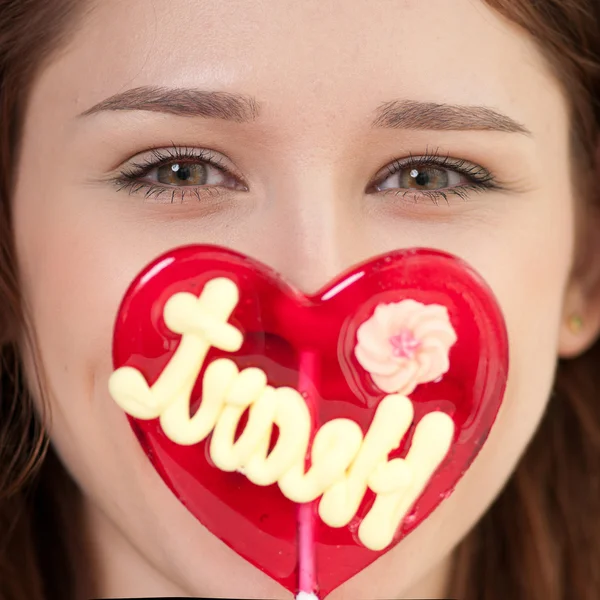 Pretty woman with candy heart — Stock Photo, Image