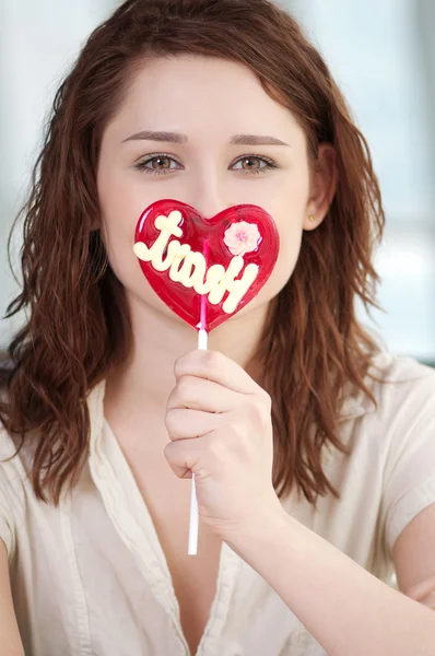 Pretty woman with candy heart — Stock Photo, Image