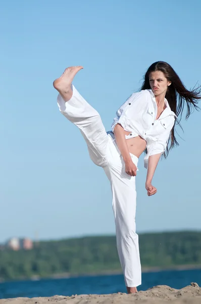 Mulher atlética realizando um chute — Fotografia de Stock