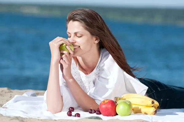 Kvinna på strand äta frukter — Stockfoto