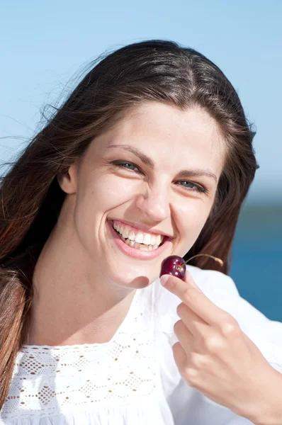 Donna sulla spiaggia mangiare frutta — Foto Stock