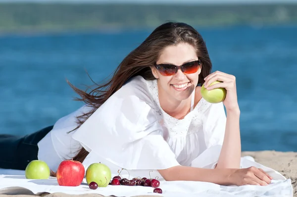 Γυναίκα στην παραλία τρώει φρούτα — Φωτογραφία Αρχείου