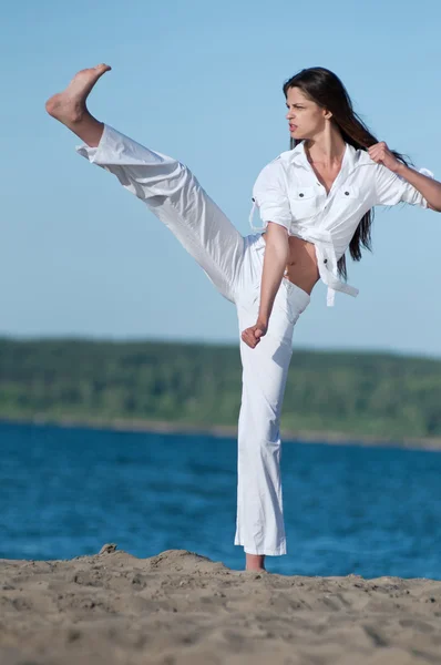 Athletic woman performing a kick — Stock Photo, Image