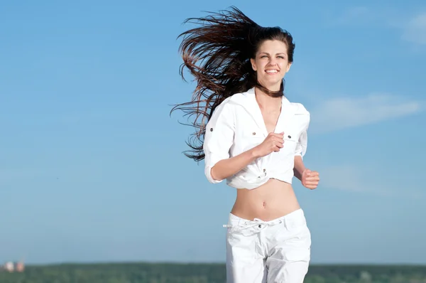 Mujer deportiva corriendo en la costa del mar — Foto de Stock