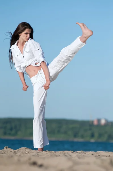 Athletic woman performing a kick — Stock Photo, Image